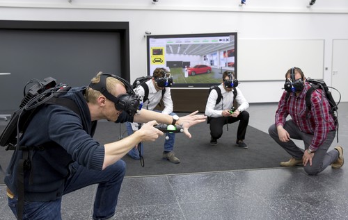 Martin Rademacher (links) und seine Kollegen aus der Audi-Planung testen das Virtual Reality Holodeck, um das Design eines neuen Automodells zu beurteilen.